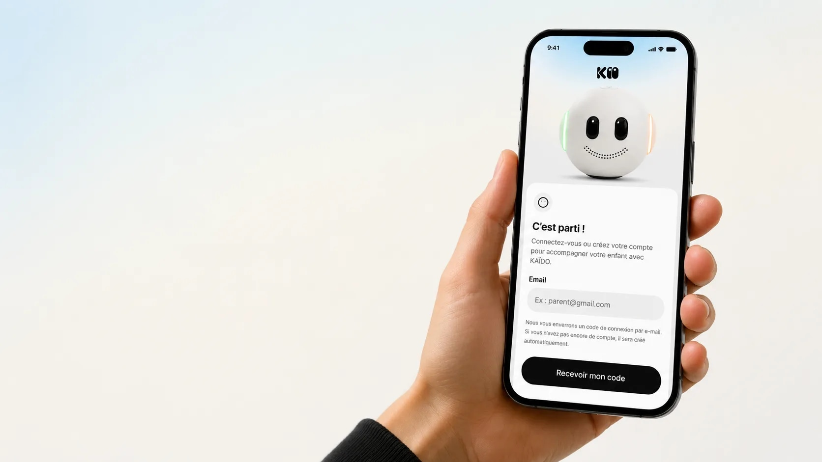 A parent holds an iPhone showing the KAÏDO app