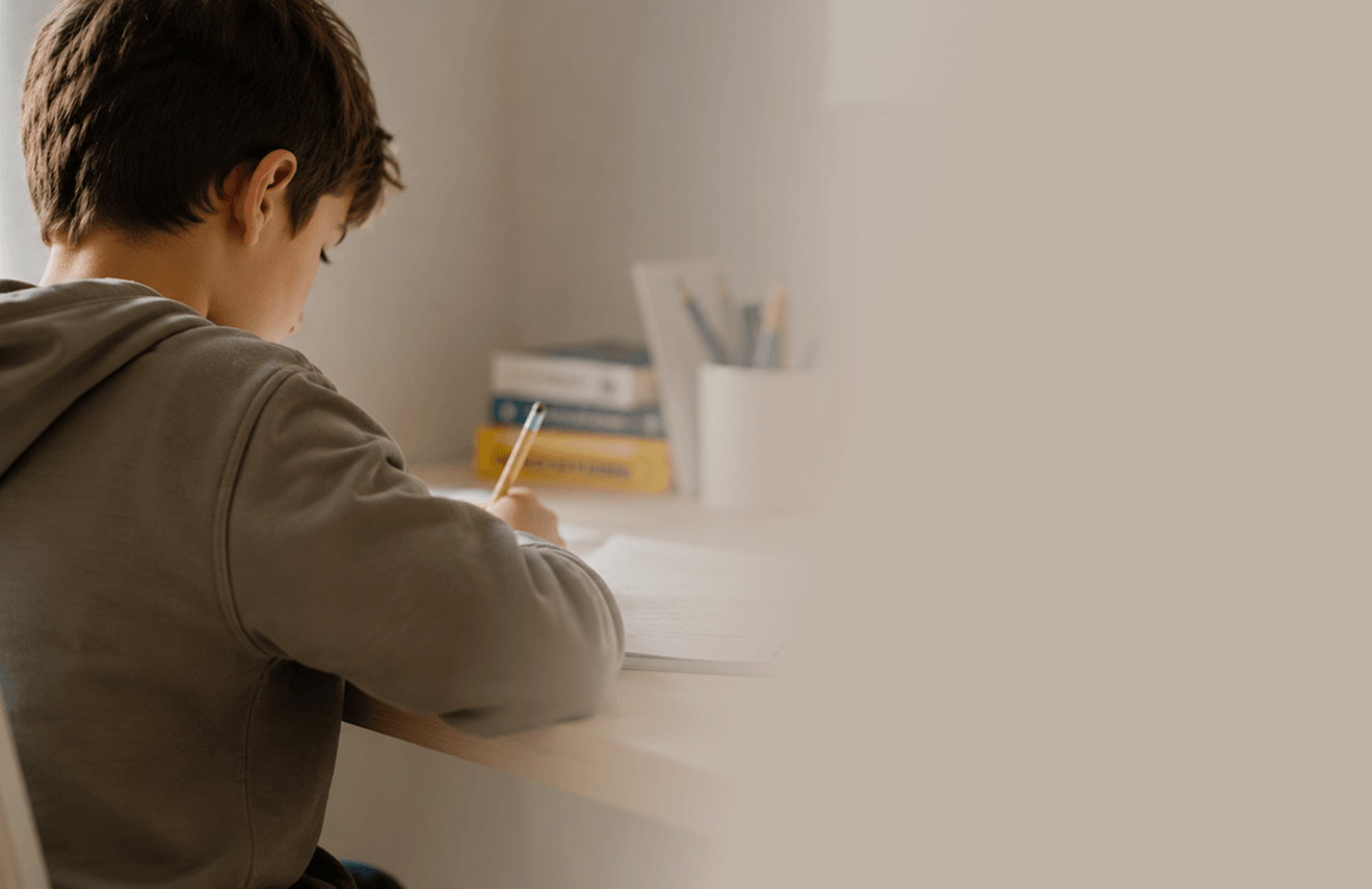 A child doing their homework at their desk, the KAÏDO sphere beside them